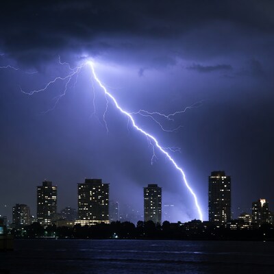 Lightning striking city skyline over water