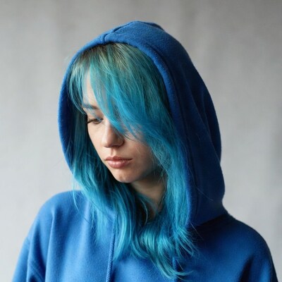 Woman with turquoise hair in blue hoodie