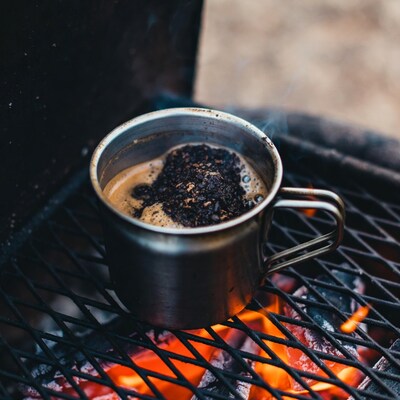 Coffee mug on campfire grate