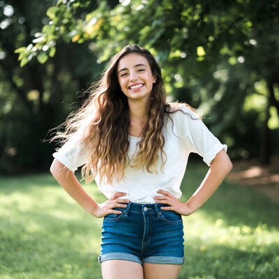 Smiling woman in white top and denim shorts