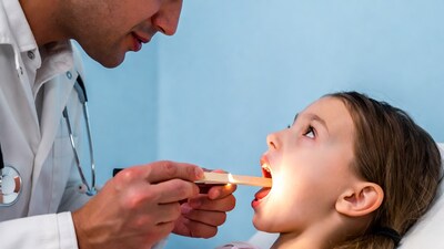 Doctor examining girl's throat