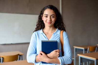 Young woman holding book in classroom