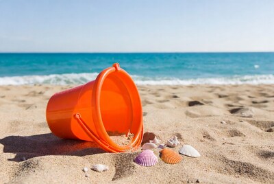 Orange beach pail spilling seashells
