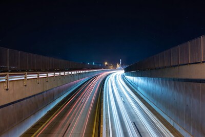 Night highway light trails under bridge