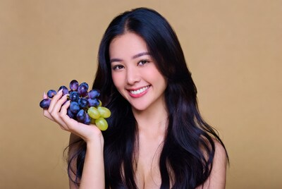 Asian woman holding grapes
