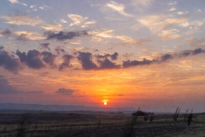 Sunset over grassy plains and mountains