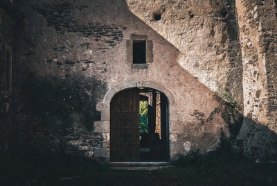Open wooden door in stone archway