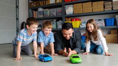 Dad and kids playing toy cars in garage