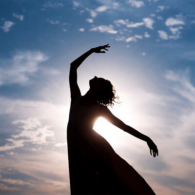 Woman dancing silhouette against sunset sky