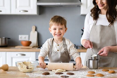 Boy and mom baking cookies in kitchen