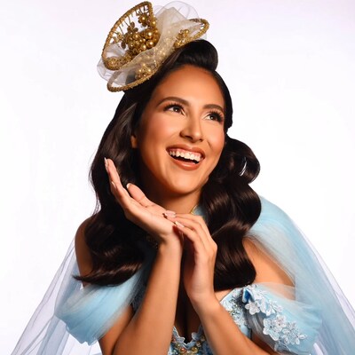 Latina woman in gold crown hat smiling