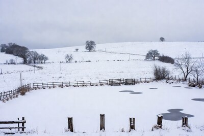 Snowy Farm Field with Fence and Ponds
