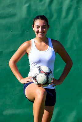 Smiling girl holding soccer ball