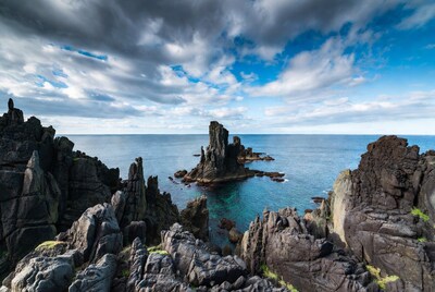Woman overlooking sea stacks cliffs