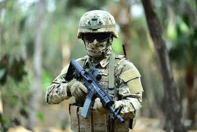 Soldier holding rifle in jungle