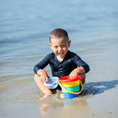 Toddler boy with beach toys