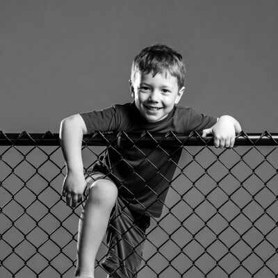 Boy smiling over chain link fence