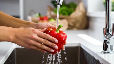 Woman washing red bell pepper