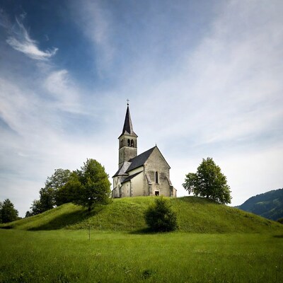 Church on grassy hill with mountains