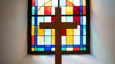 Wooden Cross Before Stained Glass Window