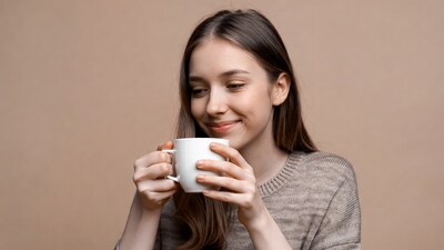 Young woman drinking from white mug