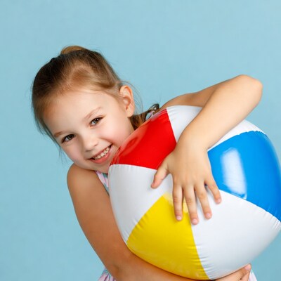Girl hugging colorful beach ball