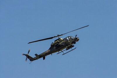 Military helicopter flying in blue sky