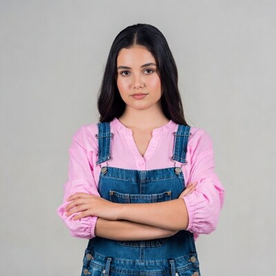 Girl in denim overalls with arms crossed
