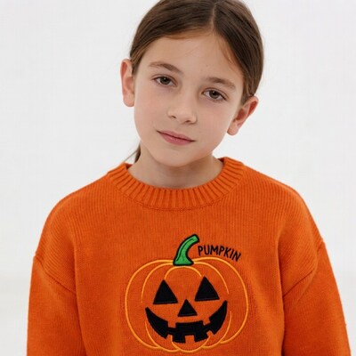 Girl wearing pumpkin Halloween sweater