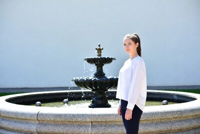 Young woman standing by fountain