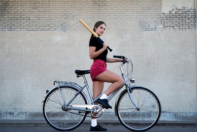 Woman with baseball bat on bicycle