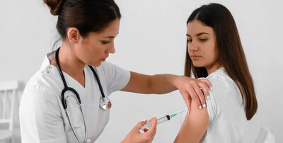 Nurse giving girl vaccine injection