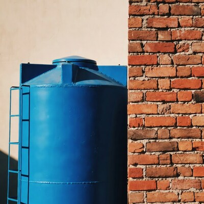 Blue water tank against brick wall