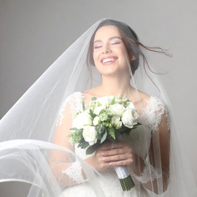 Bride holding white bouquet with flowing veil