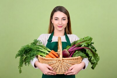 Woman holding basket of fresh vegetables