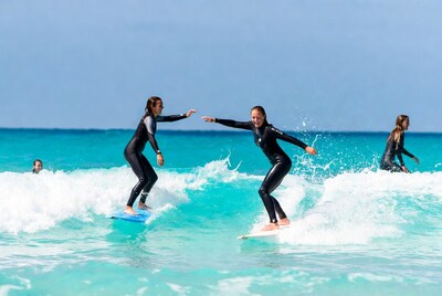 Women surfing turquoise waves