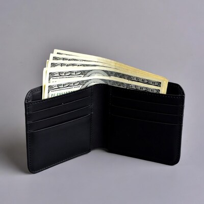 Open black leather wallet with cash