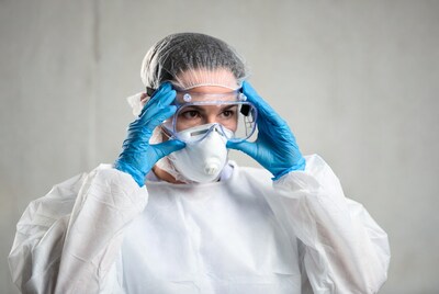 Woman adjusting PPE goggles and mask