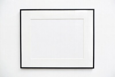 Empty black picture frame on white wall