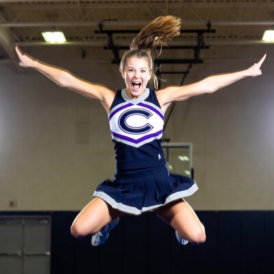 Cheerleader jumping with arms raised