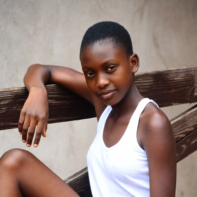 African girl leaning on wooden fence