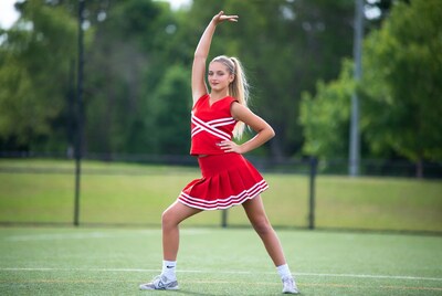 Teen girl cheerleader posing on field