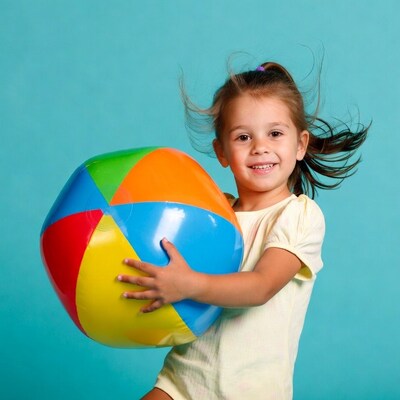 Girl holding colorful beach ball