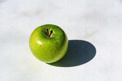 Green apple on white surface