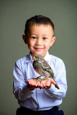 Asian boy holding sparrow bird