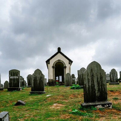 White Mausoleum in Cemetery Under Cloudy Sky