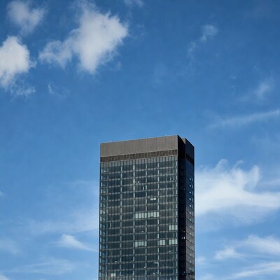 Tall glass skyscraper against blue sky