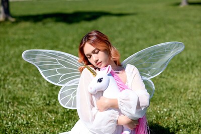 Asian woman holding unicorn with fairy wings