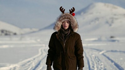 Woman with reindeer antlers in snowy landscape