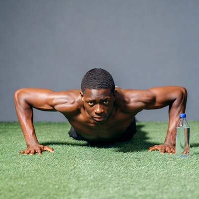 African-American man doing pushups on grass